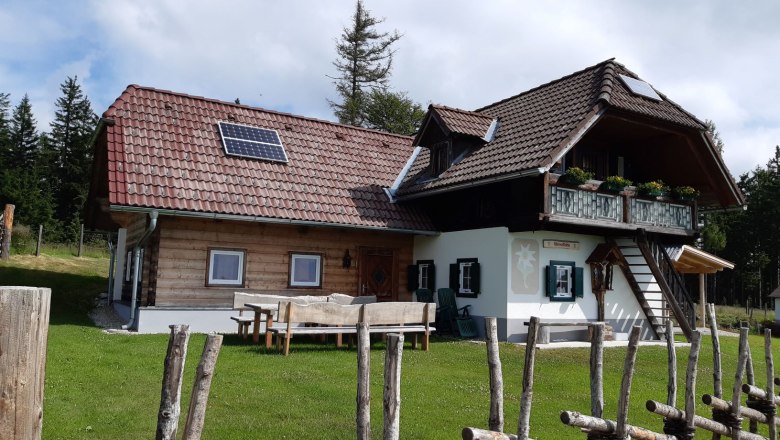 Edelweiss hut Waldtoni, © Fam. Wetzelhütter Egy téglás turistaház, amelyet egy zöld rét és egy fakerítés vesz körül.