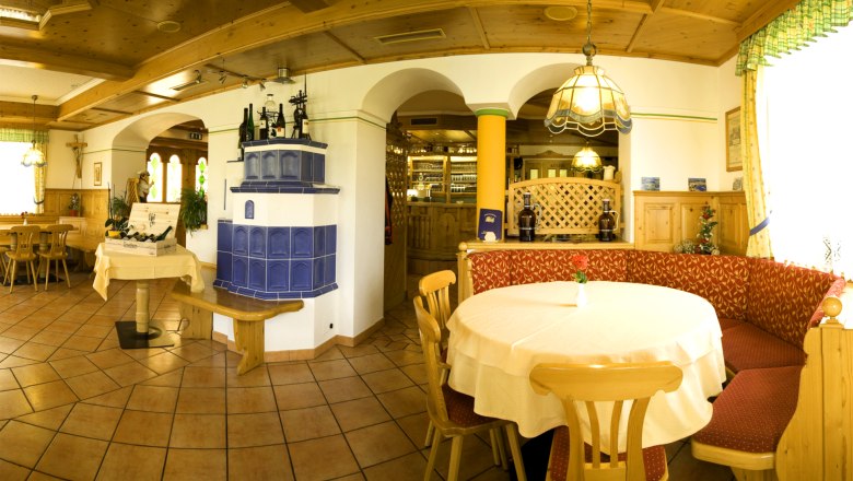 Kutscherwirt, © Fam. Romirer Gemütliches Restaurant mit Holzmöbeln, blauem Kachelofen und dekorativen Elementen.