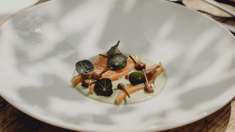 Lachsforelle, Kapuzinerkresse-Creme, Kapuzinerkresse, Schnittlauchknospen, © Niederösterreich Werbung/Sophie Menegaldo Ein Teller mit Lachsforelle, Kapuzinerkresse-Creme, Kapuzinerkresseblättern und Schnittlauchknospen.