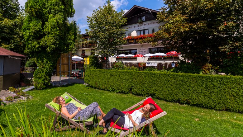 Nach der Wanderung entspannen, © Wiener Alpen / Christian Kremsl Zwei Frauen entspannen in Liegestühlen im Garten eines Gasthofs.