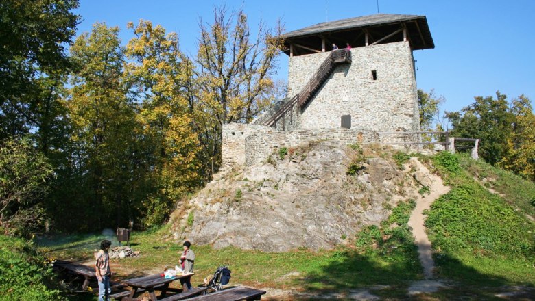 Óház Aussichtsturm, © Walter Laschober Steinerner Turm auf einem Hügel mit Picknicktischen im Vordergrund.