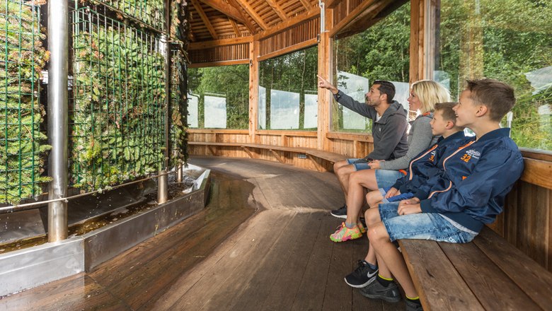 Salaerium, © Erlebnisalm Mönichkirchen, Martin Fülöp Familie sitzt in einem Holzpavillon vor einer Saline.