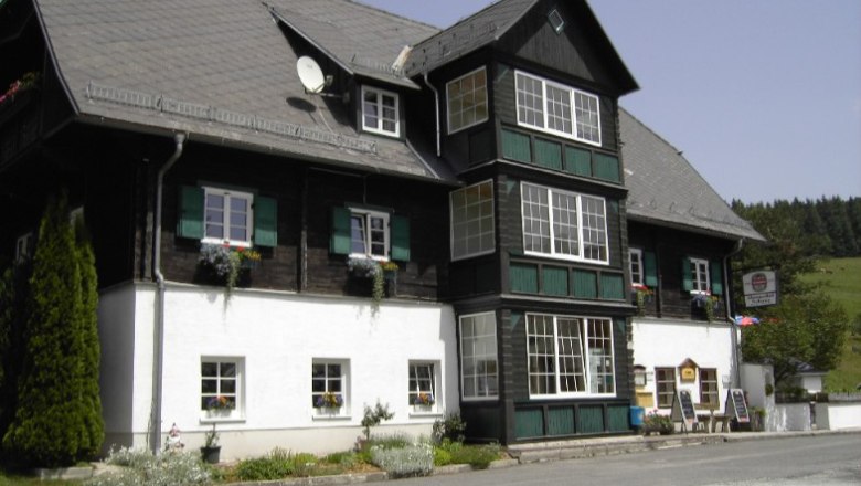 Alpengasthof Schanz, © Alpengasthof Schanz Traditionelles Gasthaus in alpiner Umgebung mit Blumen an den Fenstern.