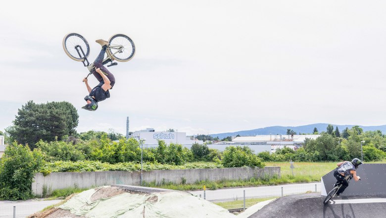 pump & jump track Wiener Neustadt, © Michi Weller Zwei BMX-Fahrer auf einer Pumptrack-Anlage, einer macht einen Rückwärtssalto, der andere fährt eine Kurve.