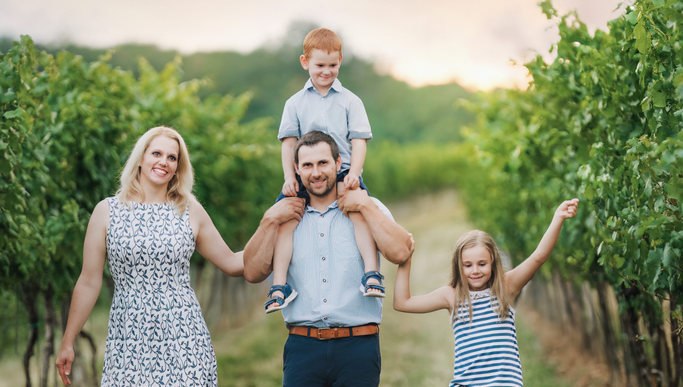 Familie Seid - Weinviertler Heuriger, © Martin Mathes Familie spaziert durch einen Weinberg bei Sonnenuntergang.
