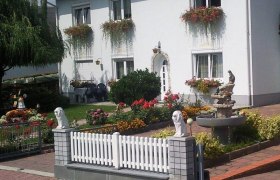 Ferienwohnung Mittermüller, © Joachim Mittermüller Ein weißes Haus mit Blumenkästen und gepflegtem Garten.