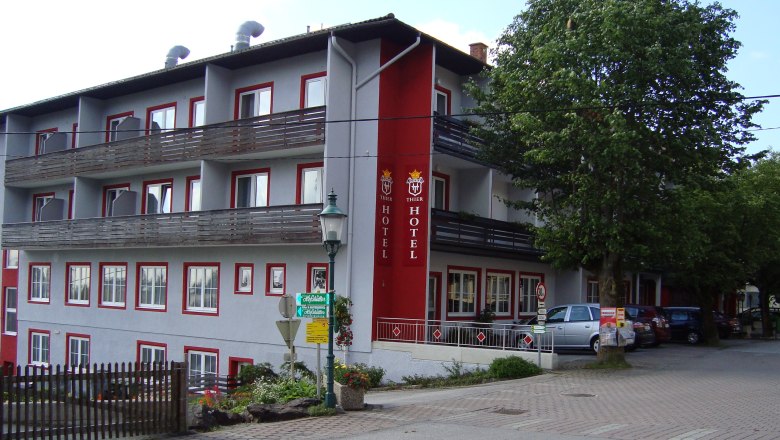 Thier Szálloda, © Hotel Thier A Hotel Thier külső nézete erkélyekkel és piros felirattal.