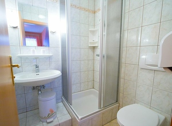 Pension Koderholt, © Koderholt Kleines Badezimmer mit Dusche, Waschbecken und Toilette.