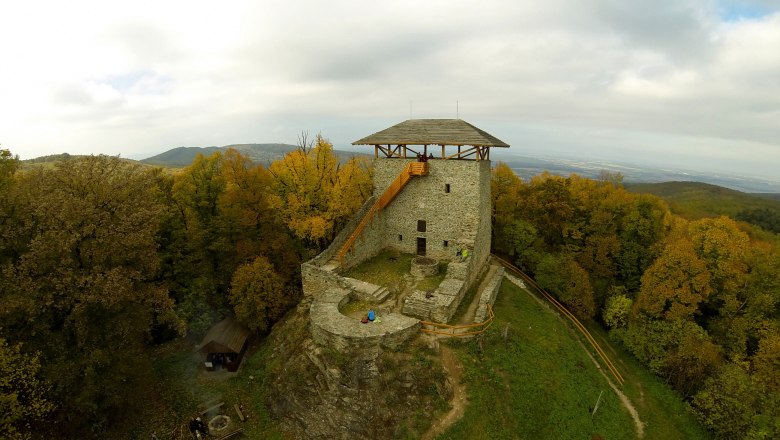 Althaus Aussichtsturm, © Óház Luftaufnahme eines alten Steinturms auf einem Hügel, umgeben von herbstlichen Bäumen.