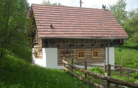 Schüttkasten, © Hannelore Meichenitsch Ein traditionelles Holzhaus mit Ziegeldach in einer grünen Landschaft.