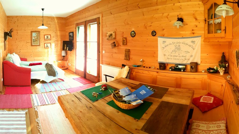A hangulatos Weiglhütte, © Weiglhütte, Foto: Stefan Zimprich Hangulatos szoba egy faházban, kanapéval, asztallal és dekorációval.