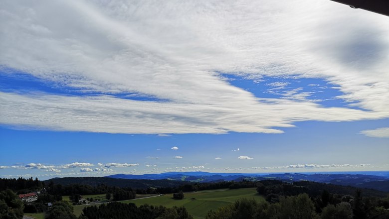 Hotel Thier, © Franz Thier Landschaft mit Hügeln, Wäldern und weitem Himmel mit Wolken.