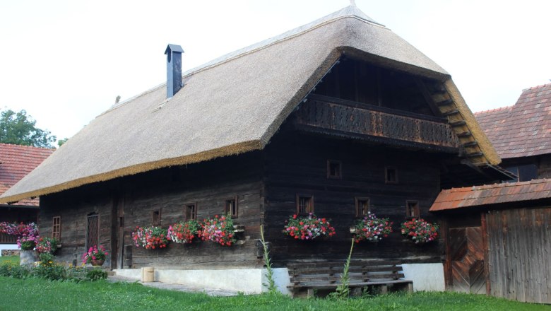 Vorau Szabadtéri Múzeum, © Freilichtmuseum Vorau Hagyományos faház nádtetővel és virágládákkal a voraui szabadtéri múzeumban.