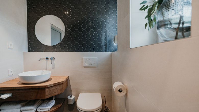 Neue Badezimmer, © Der Löffler - Nicole Seiser Modernes Badezimmer mit Waschbecken, Spiegel und Toilette.