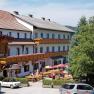 Gasthof-Pension &Ouml;denhof mit Terrasse und geparkten Autos.