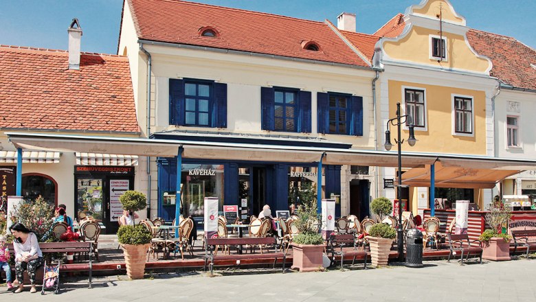 Hotel Portré, © Portré-Étterem és Panzió Straßencafé vor einem gelben Gebäude mit rotem Dach.