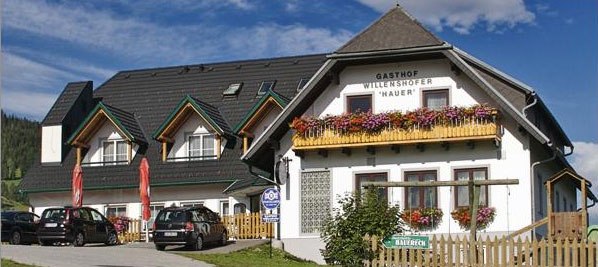 Weißes einstöckiges Gebäude mit Blumenbalkon.