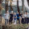 Eine Gruppe von Menschen in Kochkleidung steht fr&ouml;hlich in einem Wald.