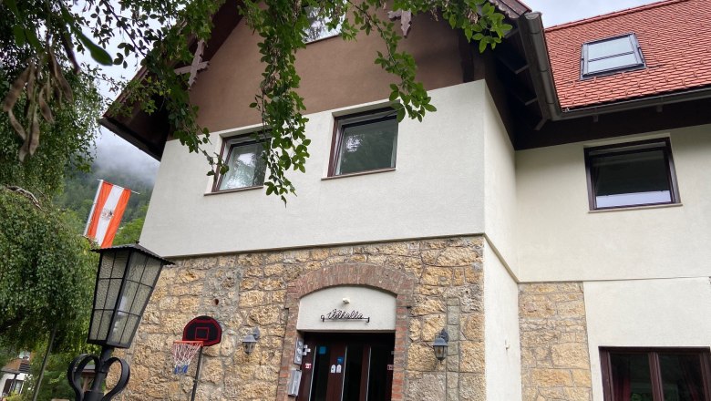 Villa Wellspacher im Sommer, © Wiener Alpen Fassade der Villa Wellspacher mit österreichischer Flagge und Basketballkorb.