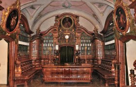 Historische Apotheke mit Holzinterieur und Gemälden.