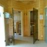 Innenansicht einer Sauna mit Holzw&auml;nden, Glast&uuml;ren und Handt&uuml;chern.