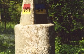 Ein Dreiländerstein im Wald, der die Grenze zwischen Burgenland, Niederösterreich und Steiermark markiert.