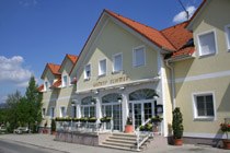 Außenansicht des Gasthof mit gelber Fassade und rotem Dach..