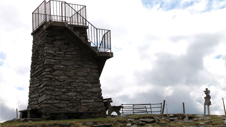 Steinerner Aussichtsturm mit Gel&auml;nder auf einem H&uuml;gel.