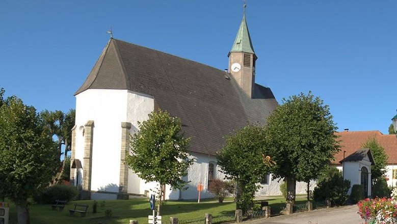 Wallfahrtskirche Maria Namen mit Turm und B&auml;umen im Vordergrund.