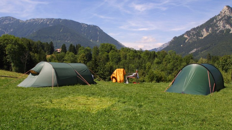 Camping beim Flackl-Wirt, © Flackl Wirt Zwei grüne Zelte auf einer Wiese mit Bergen im Hintergrund.