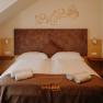 Gem&uuml;tliches Hotelzimmer mit Doppelbett, mit heller Holzverkleidung und erdigen Farbt&ouml;nen.