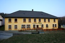 Gelbes zweistöckiges Gebäude mit der Aufschrift 'Gasthof Pürrer'.