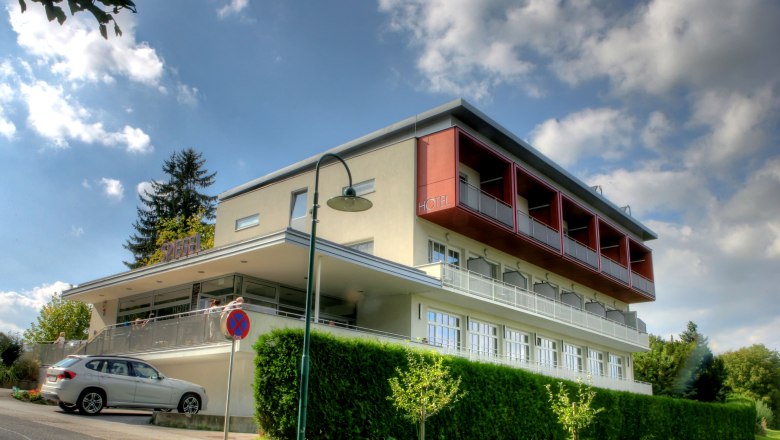 Modernes zweistöckiges Gebäude mit Balkonen in Hanglage.