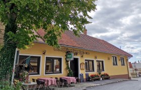 Egy hagyom&aacute;nyos vend&eacute;glő k&uuml;lső n&eacute;zete, s&aacute;rga homlokzattal &eacute;s piros tetőcser&eacute;ppel.