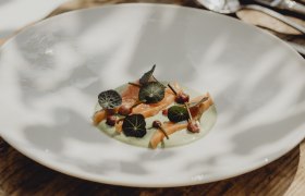 Ein Teller mit Lachsforelle, Kapuzinerkresse-Creme, Kapuzinerkressebl&auml;ttern und Schnittlauchknospen.