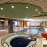 Innenpoolbereich mit Whirlpool und Liegest&uuml;hlen im Hotel Thier.
