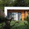 Modernes G&auml;stehaus mit Holzverkleidung und Garten.