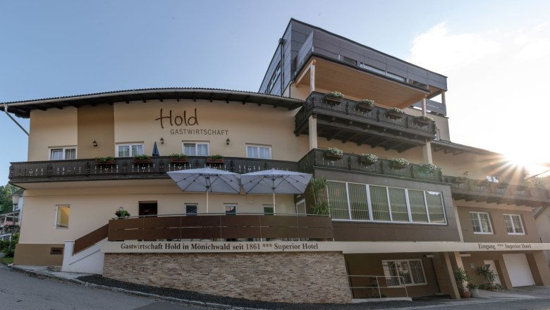 Gastwirtschaft Hold, © Tourismusverband Oststeiermark, Patrick Feiner Außenansicht der Gastwirtschaft mit Balkonen und Sonnenschirmen.