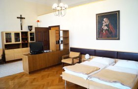 Ansicht eines Zimmers im Bildungshaus Stift Vorau mit Doppelbett und Holzm&ouml;beln.