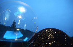 Glaskugel und beleuchtete Kuppel bei D&auml;mmerung im Freien.
