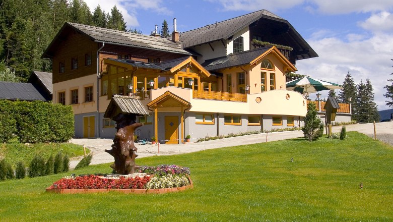 Alpengasthof Kummerbauerstadl mit Garten und Sonnenschirmen.