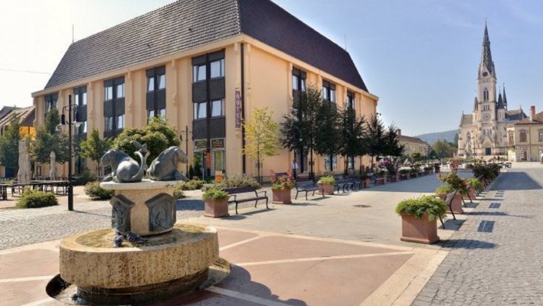 Ein Hotelgebäude mit Brunnen im Vordergrund und einer Kirche im Hintergrund.