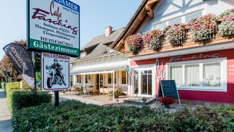 Au&szlig;enansicht eines Caf&eacute;s mit Terrasse und Blumen.