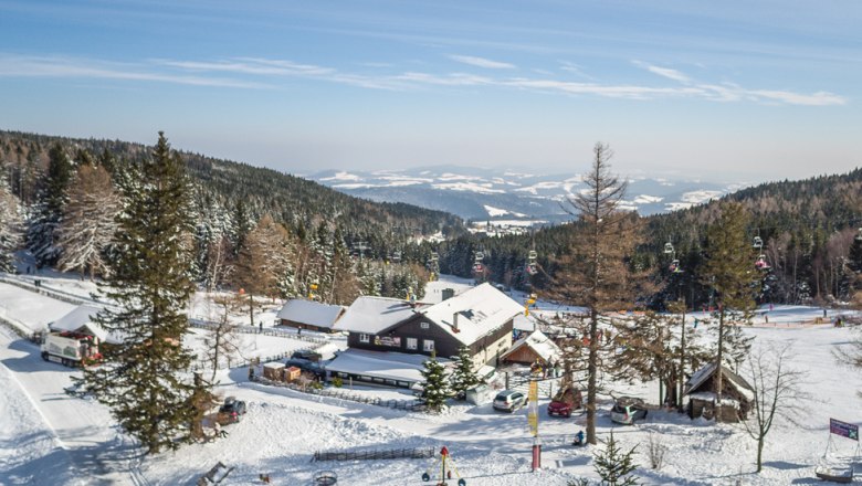 Winterlandschaft mit Berggasthof und Skilift in M&ouml;nichkirchen.
