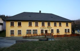 Gelbes zweistöckiges Gebäude mit der Aufschrift 'Gasthof Pürrer'.