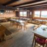 Gem&uuml;tliche Holzh&uuml;tte mit Tischen und St&uuml;hlen, rustikale Einrichtung.