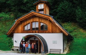 Eingang des Bergbaumuseums mit Holzfassade und Besuchergruppe davor.