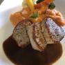 Ein Tellergericht mit Fleisch, brauner So&szlig;e, S&uuml;&szlig;kartoffelp&uuml;ree und Gem&uuml;se.