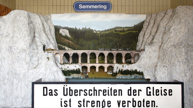 A Kalte Rinne viadukt modellje vonattal &eacute;s t&aacute;jjal a h&aacute;tt&eacute;rben. Feliratos t&aacute;bla: "A s&iacute;neken &aacute;tkelni szigor&uacute;an tilos".