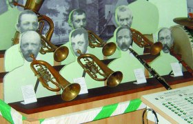 Ausstellung mit Blechblasinstrumenten und Pappfiguren.